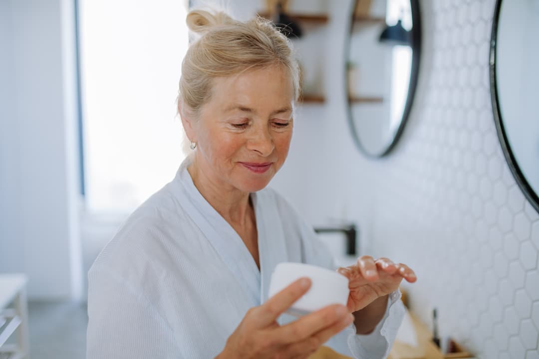 Femme dans sa salle de bain appliquant son masque à la kératine