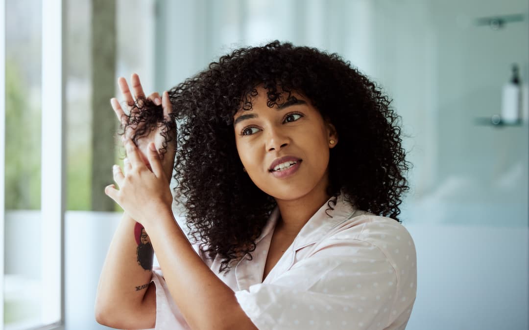 femme avec brosse cheveux bouclés