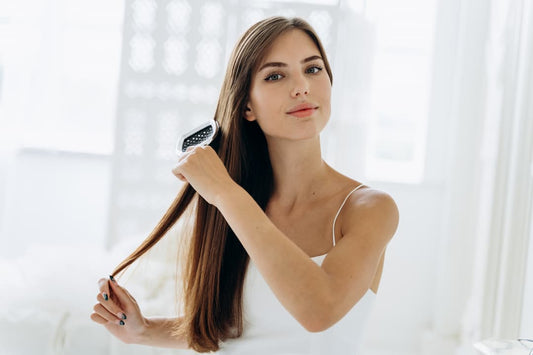 Femme lisse ses cheveux avec une brosse lissante