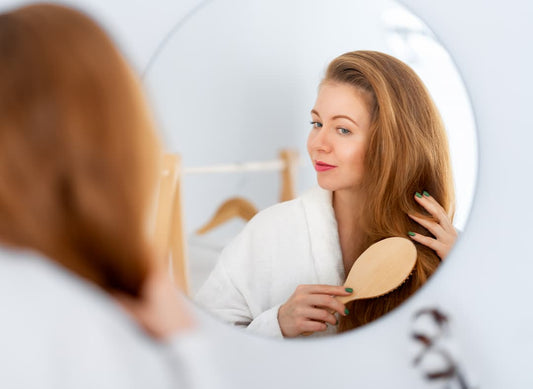 Femme devant un miroir qui se brosse les cheveux pour argile verte cheveux colorés