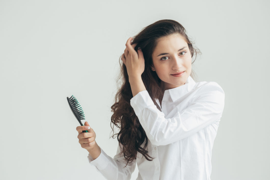 Femme avec brosse à cheveux dans les mains pour se brosser les cheveux